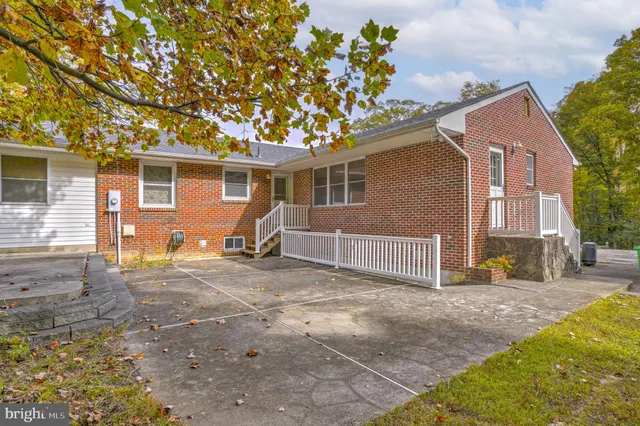 a view of a house with backyard and trees