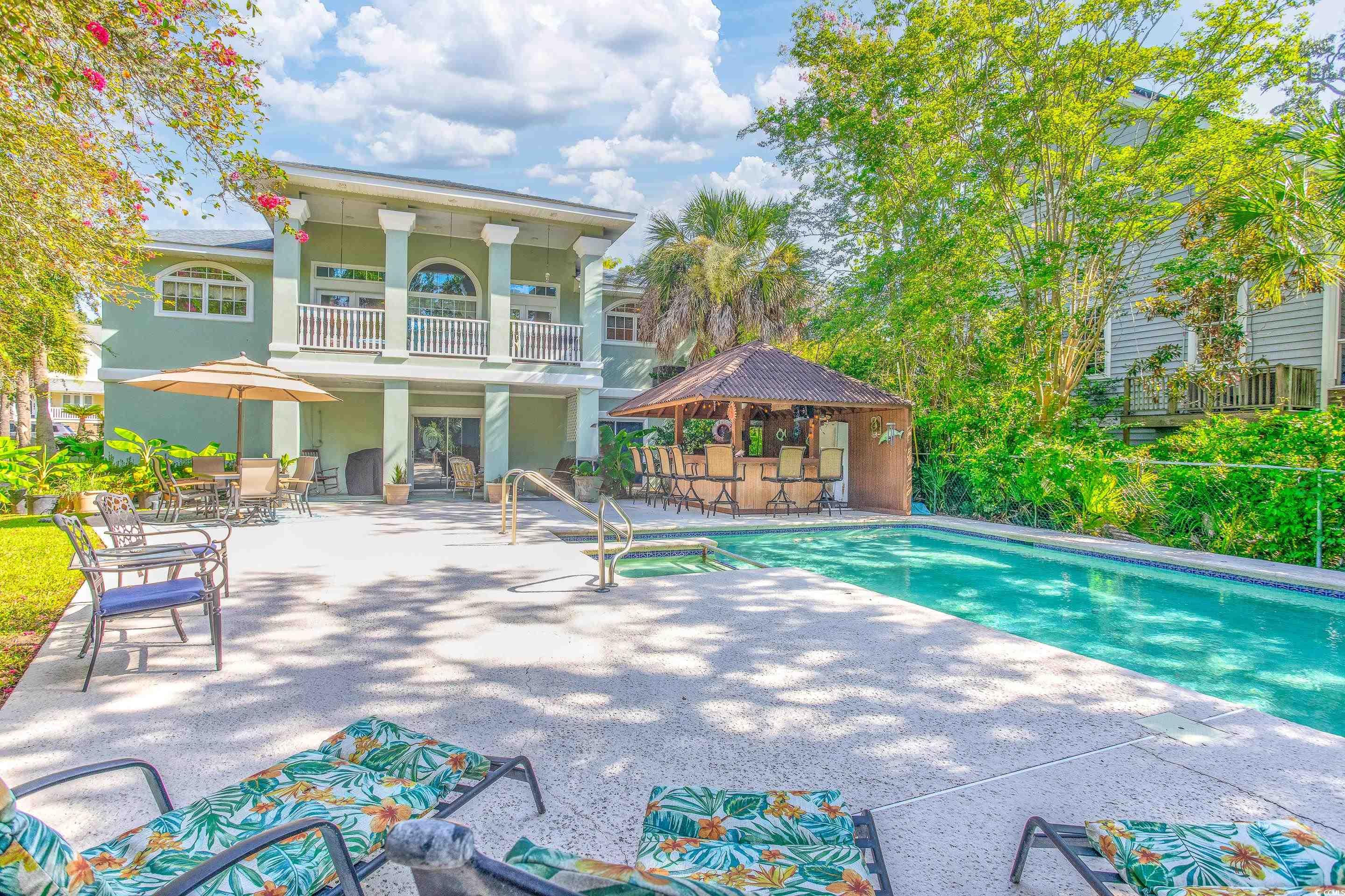 View of pool with a patio area and a pool with connected hot tub