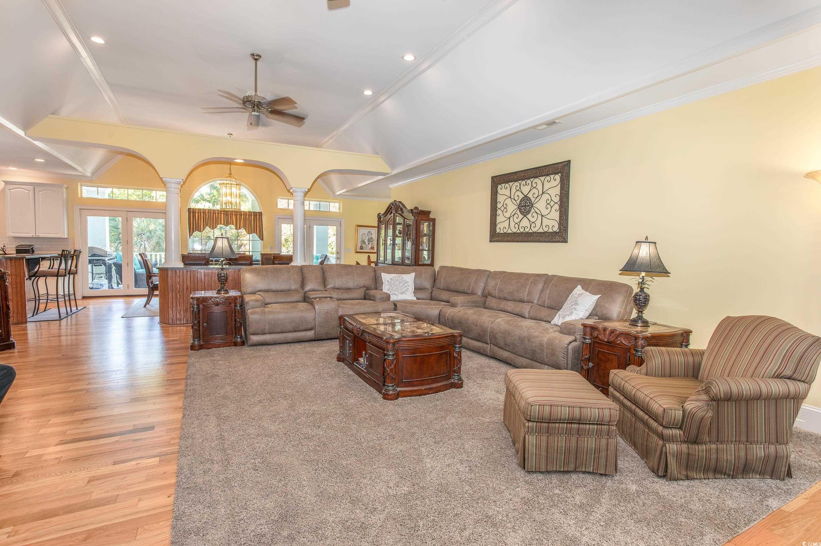 4907 Woodview Lane Myrtle Beach, SC 29575 - Photo 7 of 30 Living room with ornate columns, ceiling fan, arched walkways, light wood-style flooring, and lofted ceiling