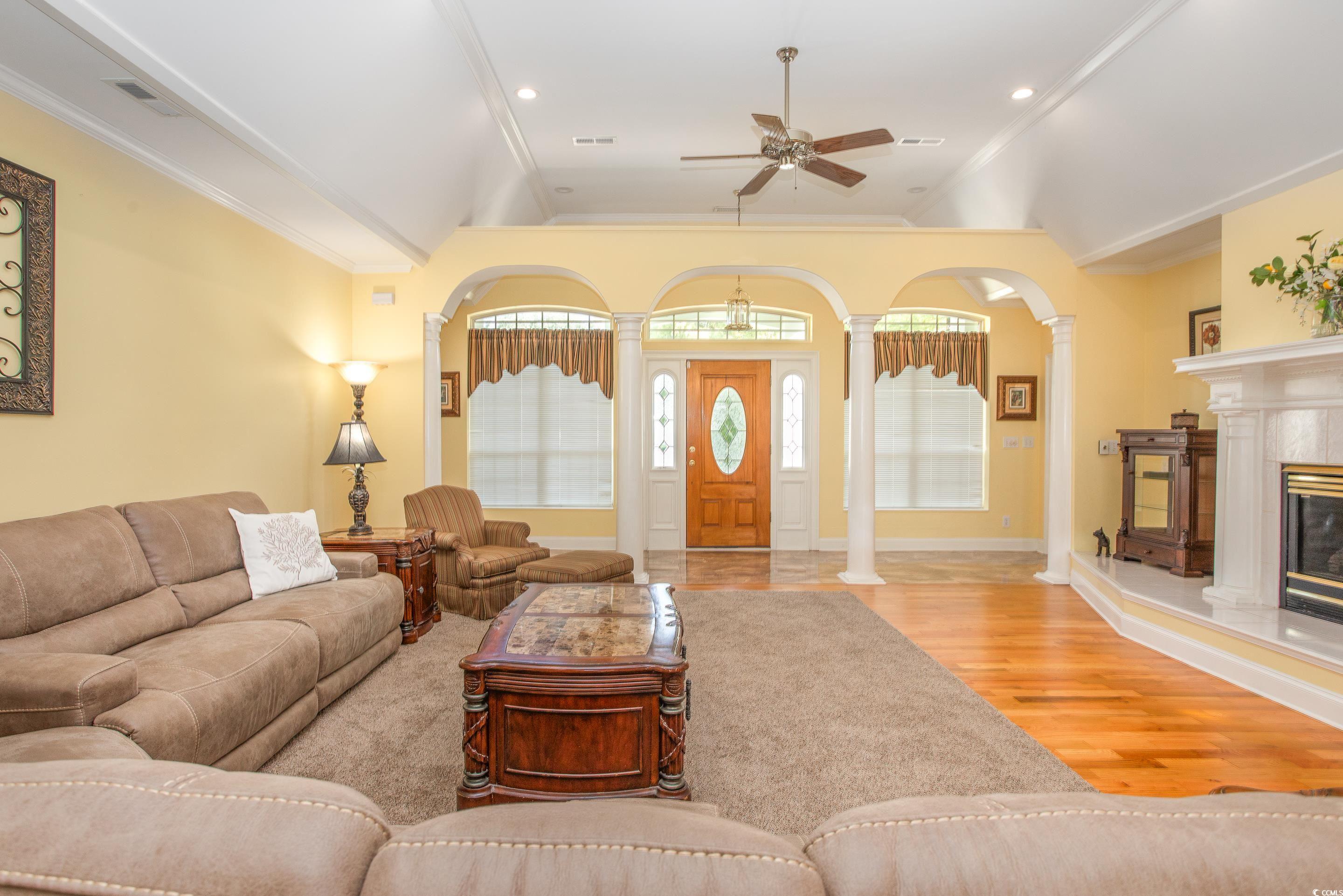 4907 Woodview Lane Myrtle Beach, SC 29575 - Photo 9 of 30 Living room featuring a ceiling fan, decorative columns, wood finished floors, lofted ceiling, and a fireplace