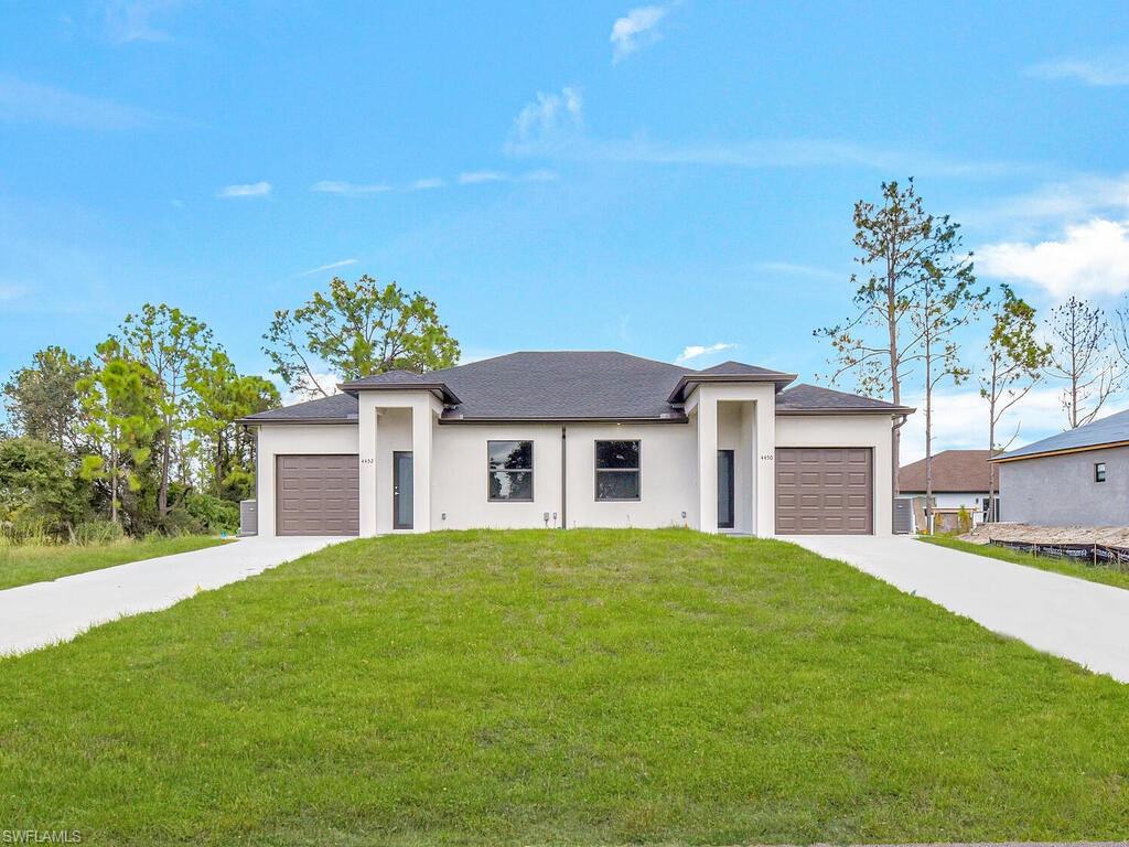 2212-2214 Wilson Road Lehigh Acres, FL 33973 - Photo 1 of 49 a front view of a house with a garden