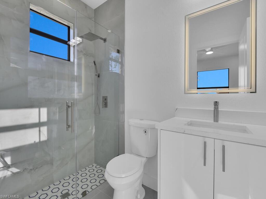 2212-2214 Wilson Road Lehigh Acres, FL 33973 - Photo 17 of 49 a bathroom with a granite countertop sink toilet and shower