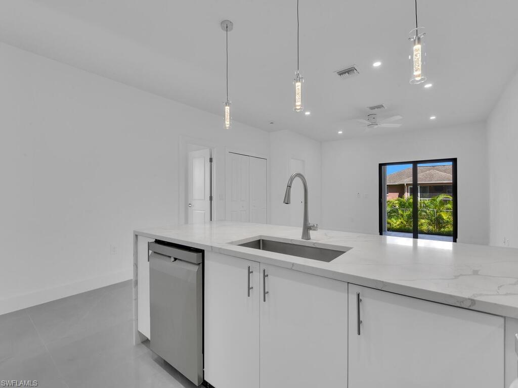 2212-2214 Wilson Road Lehigh Acres, FL 33973 - Photo 33 of 49 a kitchen with stainless steel appliances granite countertop a sink a counter space and cabinets
