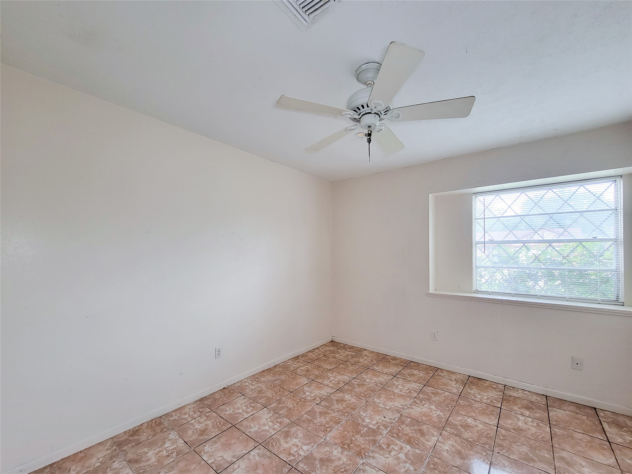 12215 Pompano Lane Houston, TX 77072 - Photo 29 of 44 an empty room with a window and a fan