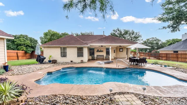 a view of a house with swimming pool and sitting area