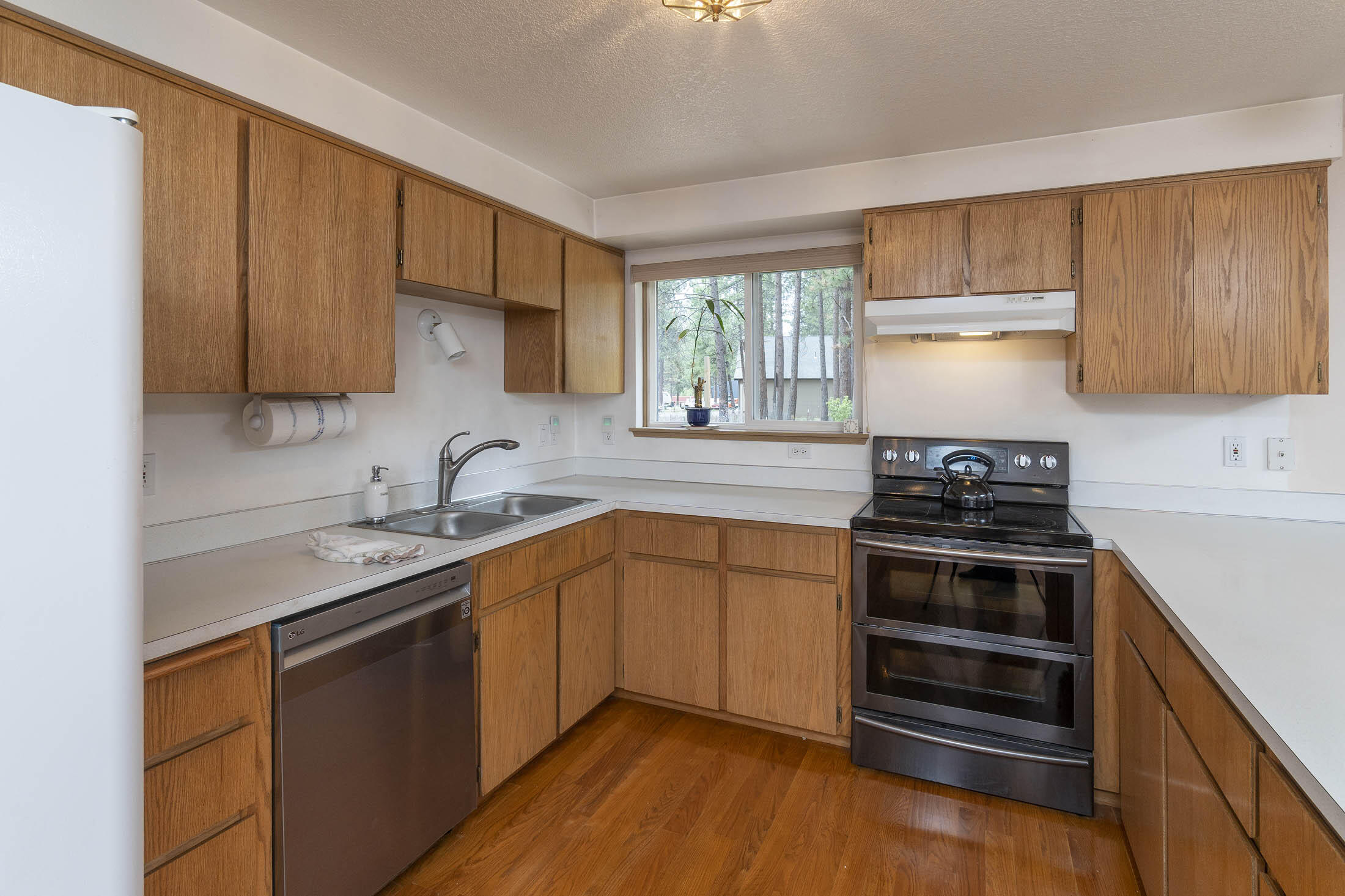 19258 Apache Road Bend, OR 97702 - Photo 7 of 23 a kitchen with stainless steel appliances a stove sink and cabinets