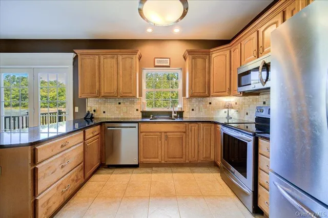 a kitchen with stainless steel appliances granite countertop a stove a sink and a microwave