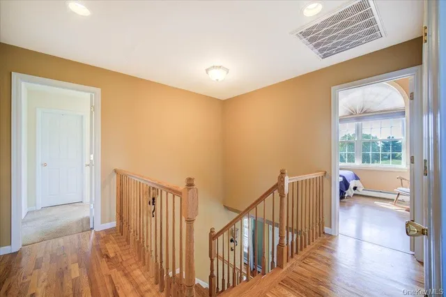 a view of a hallway with wooden floor and windows
