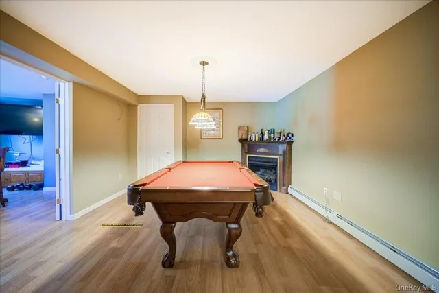 a room with pool table and wooden floor