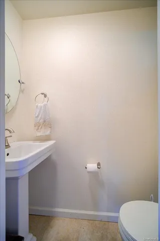 a bathroom with a sink a toilet and a mirror