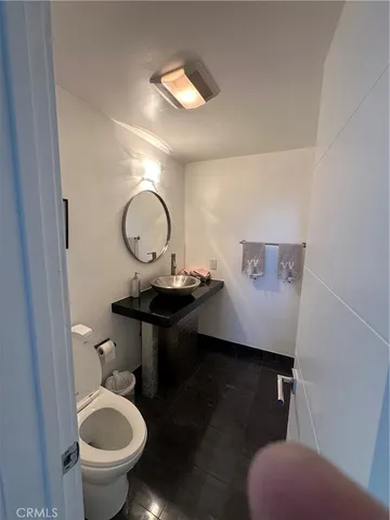 a bathroom with a toilet a sink and a mirror