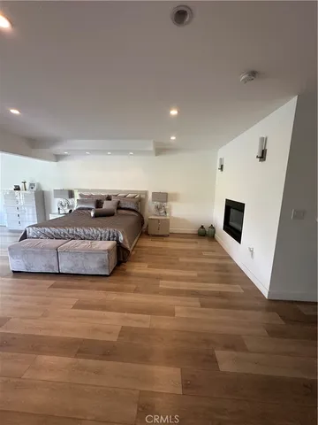 a spacious bedroom with a bed and a flat screen tv