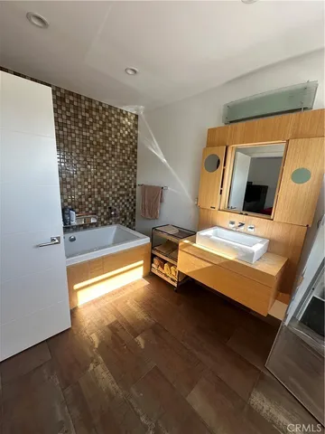 a bedroom with wooden floor and a fireplace