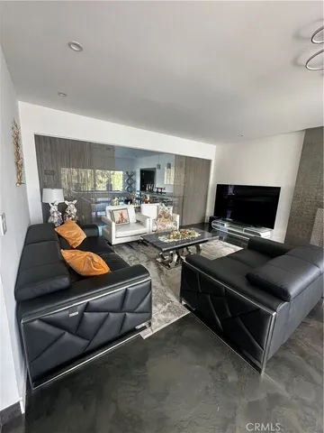 a living room with furniture a flat screen tv and a window