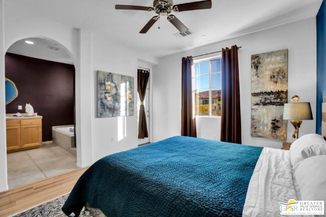 435 Copper Canyon Road, Unit 23 Palm Springs, CA 92262 - Photo 13 of 28 a bedroom with a large bed and a chandelier