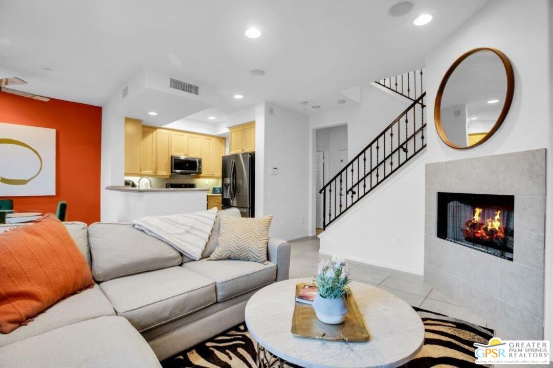 435 Copper Canyon Road, Unit 23 Palm Springs, CA 92262 - Photo 7 of 28 a living room with furniture a mirror and a fireplace