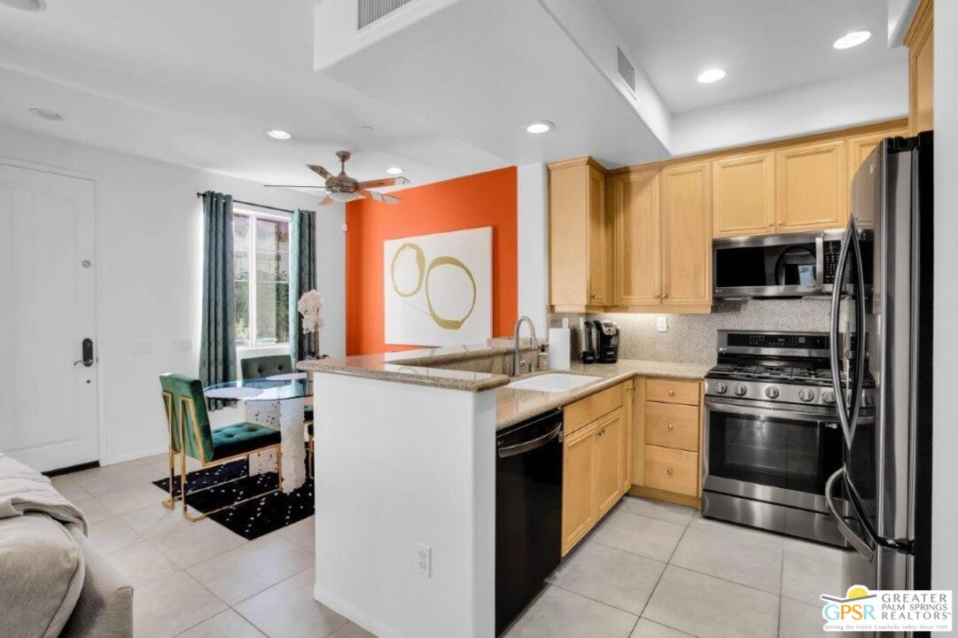 435 Copper Canyon Road, Unit 23 Palm Springs, CA 92262 - Photo 8 of 28 a kitchen with stainless steel appliances granite countertop a stove a sink and a refrigerator