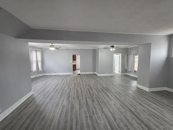 a view of empty room with wooden floor