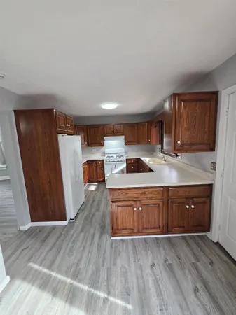 a kitchen with wooden floors and wooden cabinets