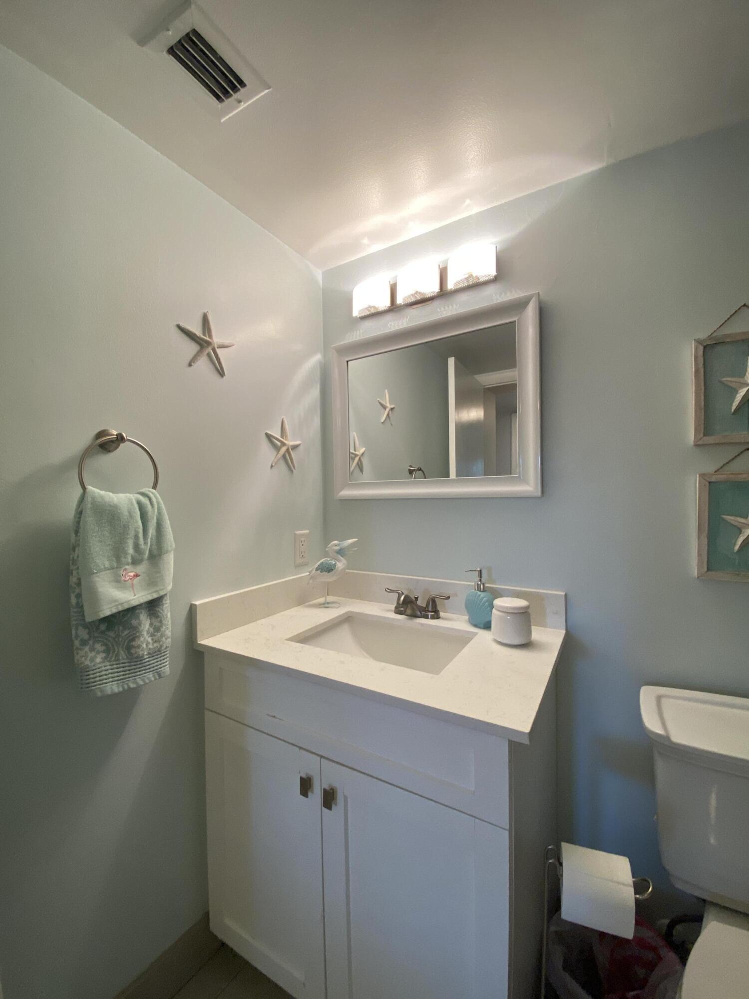 302 Pine Ridge Circle, Unit D1 Greenacres, FL 33463 - Photo 18 of 46 a bathroom with a sink and a mirror