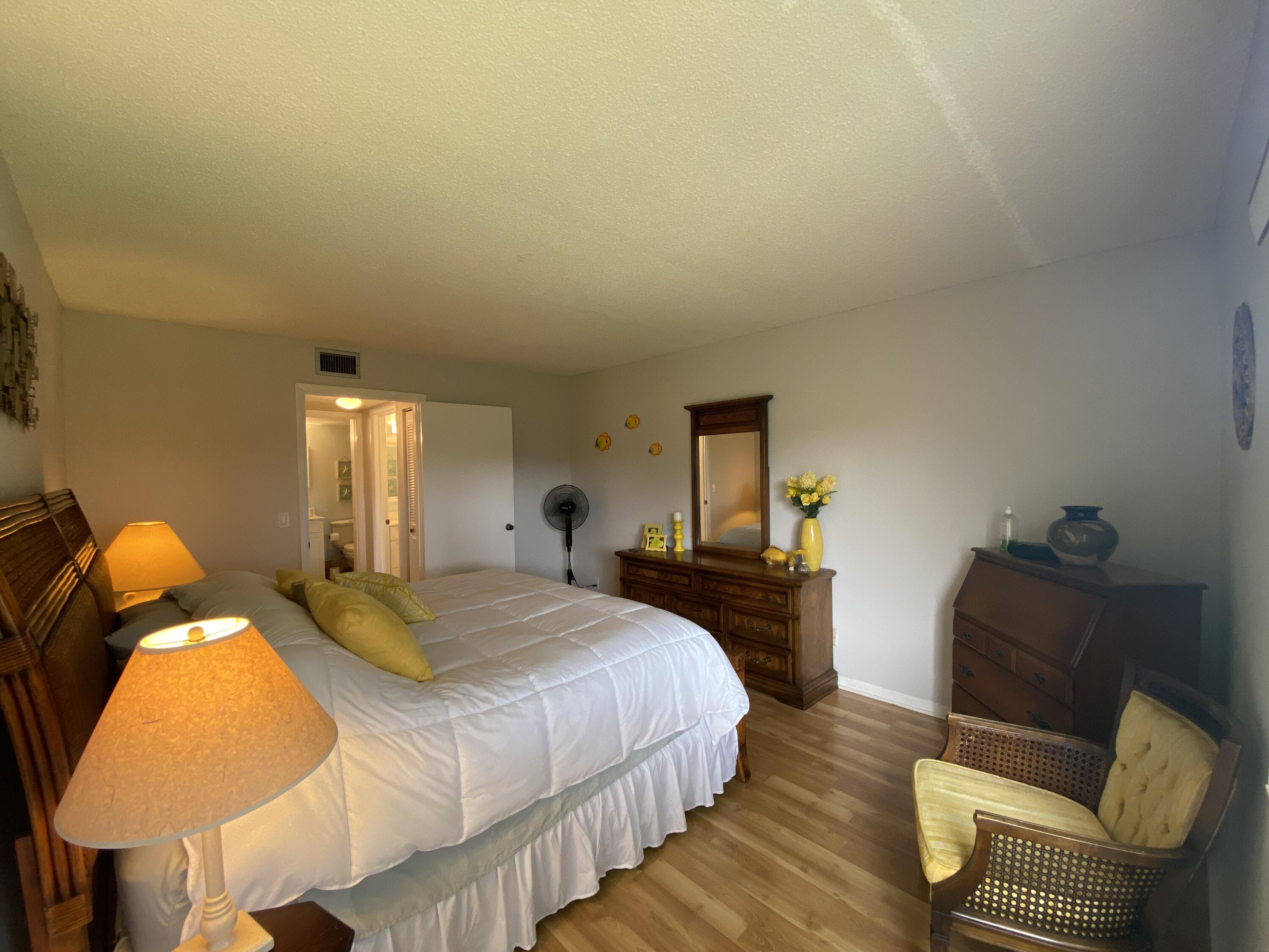 302 Pine Ridge Circle, Unit D1 Greenacres, FL 33463 - Photo 22 of 46 a bedroom with a bed and lamp