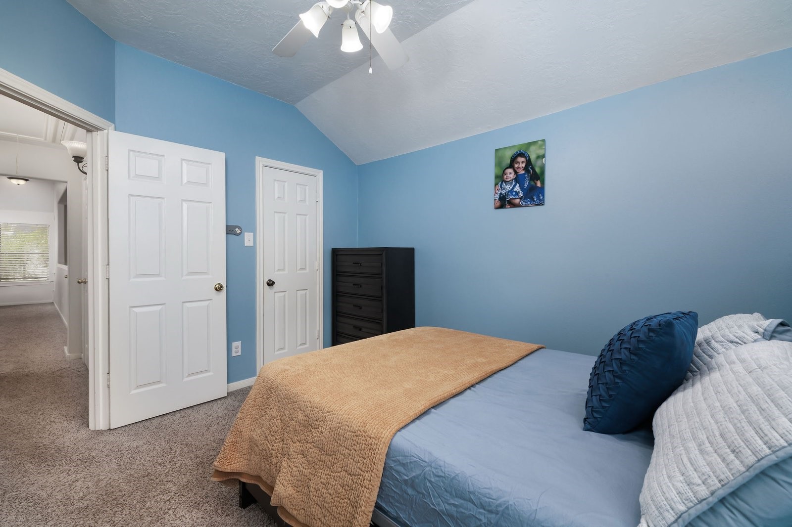 19 East Popular Pine Northeast Conroe, TX 77302 - Photo 16 of 20 a bedroom with a bed and a chandelier