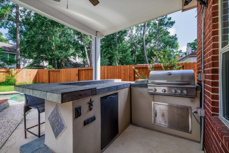 19 East Popular Pine Northeast Conroe, TX 77302 - Photo 6 of 20 a view of outdoor kitchen with dining table and chairs