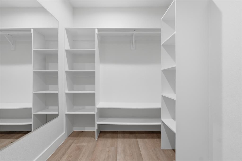 3905 Blue Ridge Boulevard Dallas, TX 75233 - Photo 16 of 25 Custom closet system with white shelving, hanging rods, and integrated full-length mirror