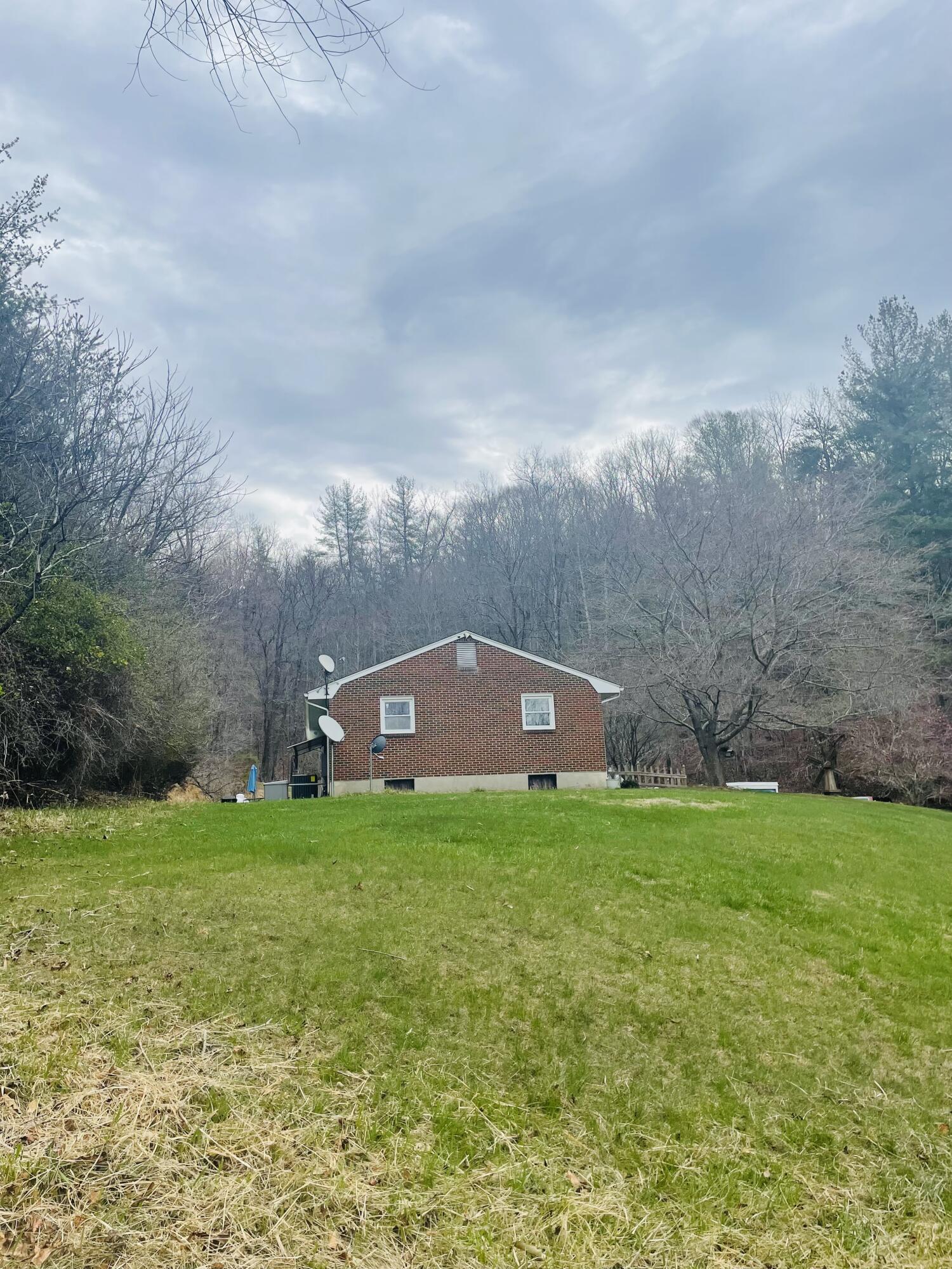 7592 Willow Branch Road Boones Mill, VA 24065 - Photo 22 of 47 a backyard of a house with lots of green space and fog