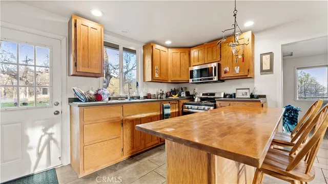 a kitchen with stainless steel appliances granite countertop a refrigerator a stove top oven a sink and dishwasher