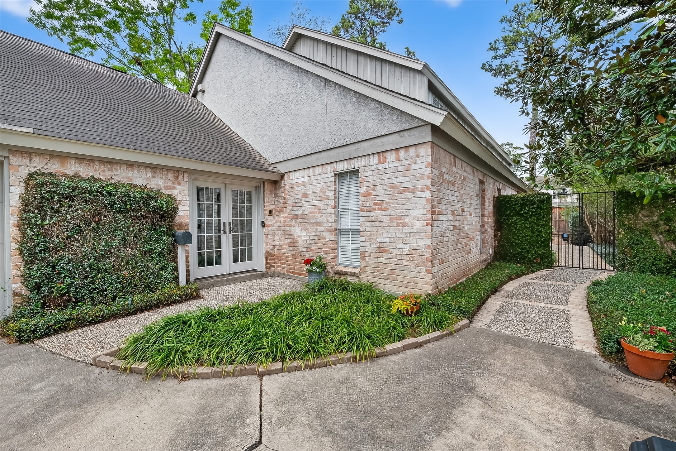10022 Bayou Glen Road Houston, TX 77042 - Photo 3 of 43 Welcome home via a charming walkway leading to your front door, framed by lush greenery and elegant brickwork.