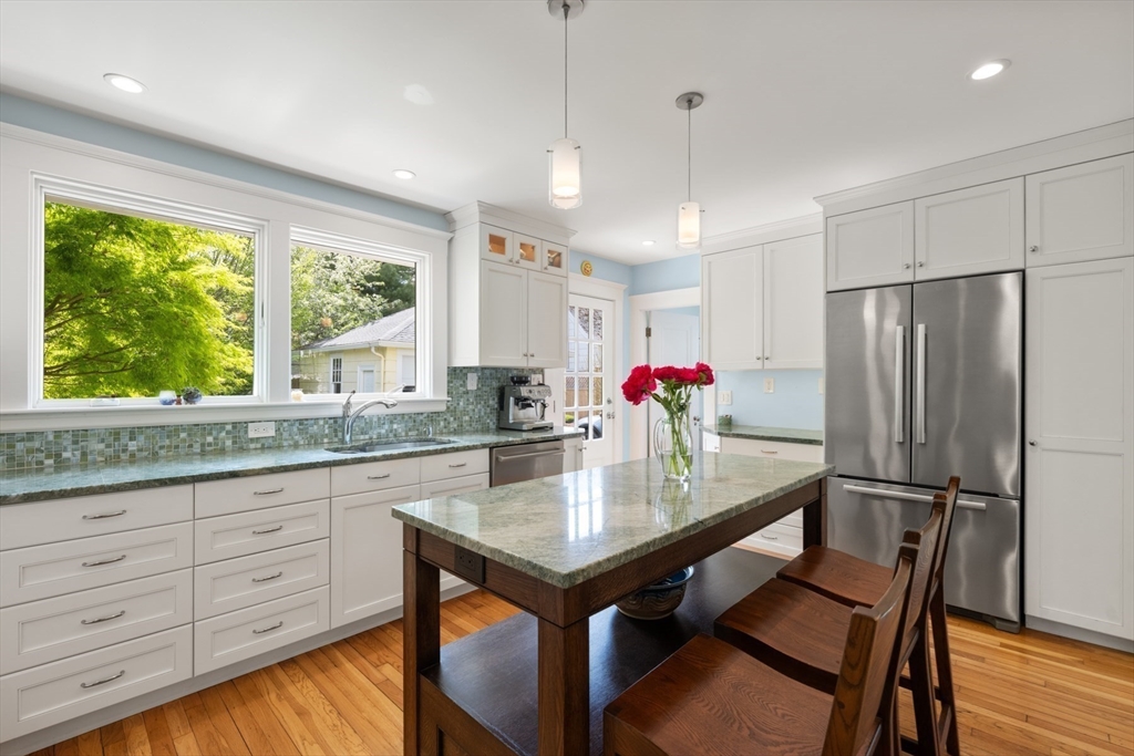 8 Charlotte Road Marblehead, MA 01945 - Photo 15 of 37 a kitchen with granite countertop a table chairs refrigerator and wooden floor