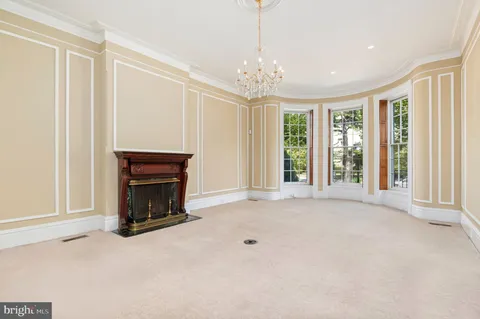 a view of an empty room with a fireplace and a window