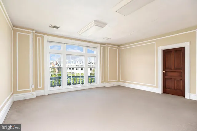 wooden floor fireplace and windows in an empty room