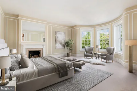 a bedroom with a large bed and a fireplace