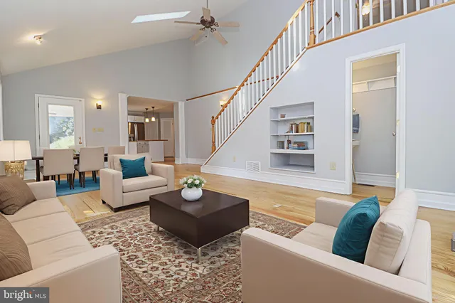a kitchen that has a sink a microwave oven a stove and white cabinets with wooden floor