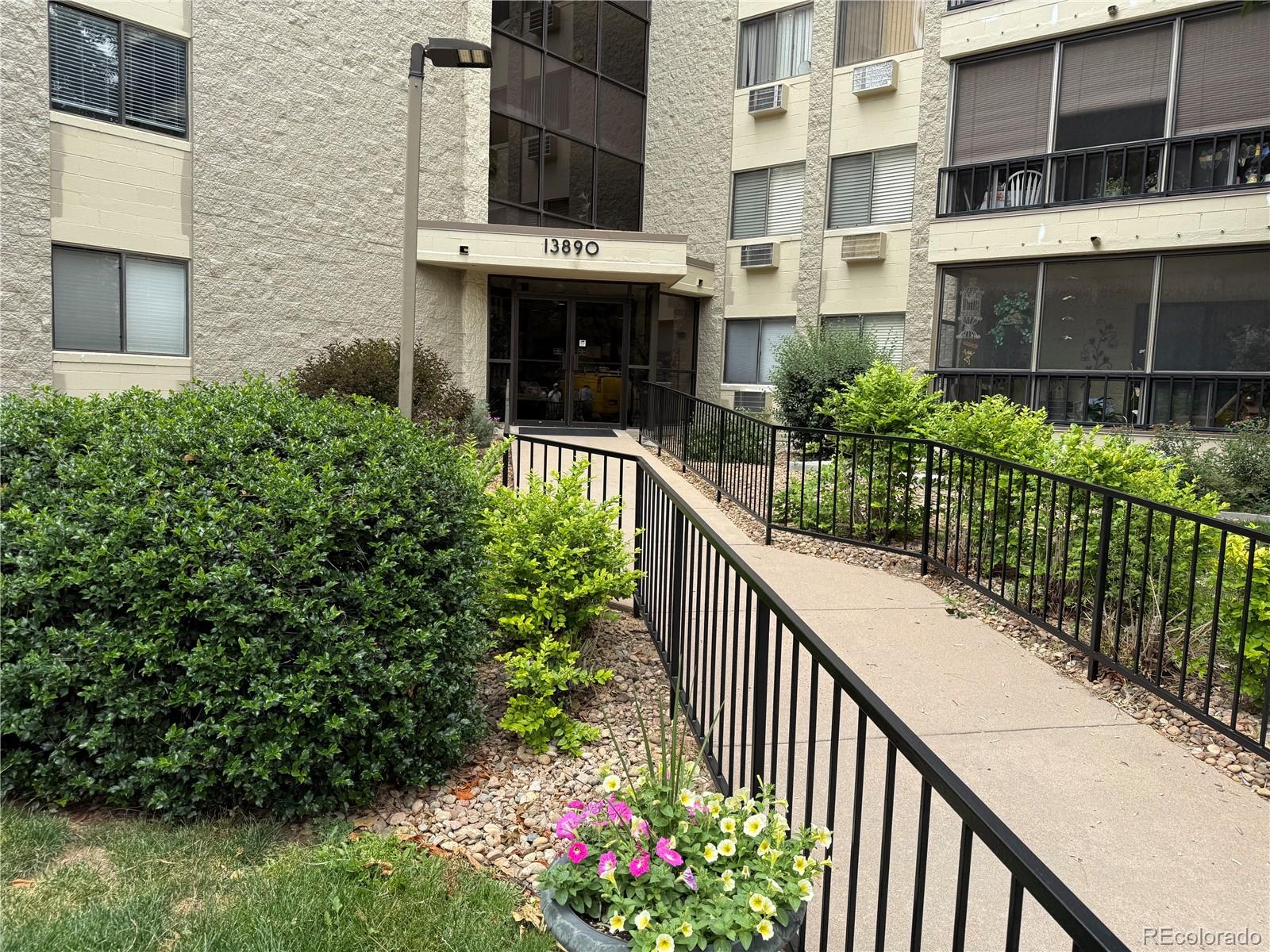 13890 East Marina Drive, Unit 602 Aurora, CO 80014 - Photo 1 of 27 a view of a house with a small yard and potted plants