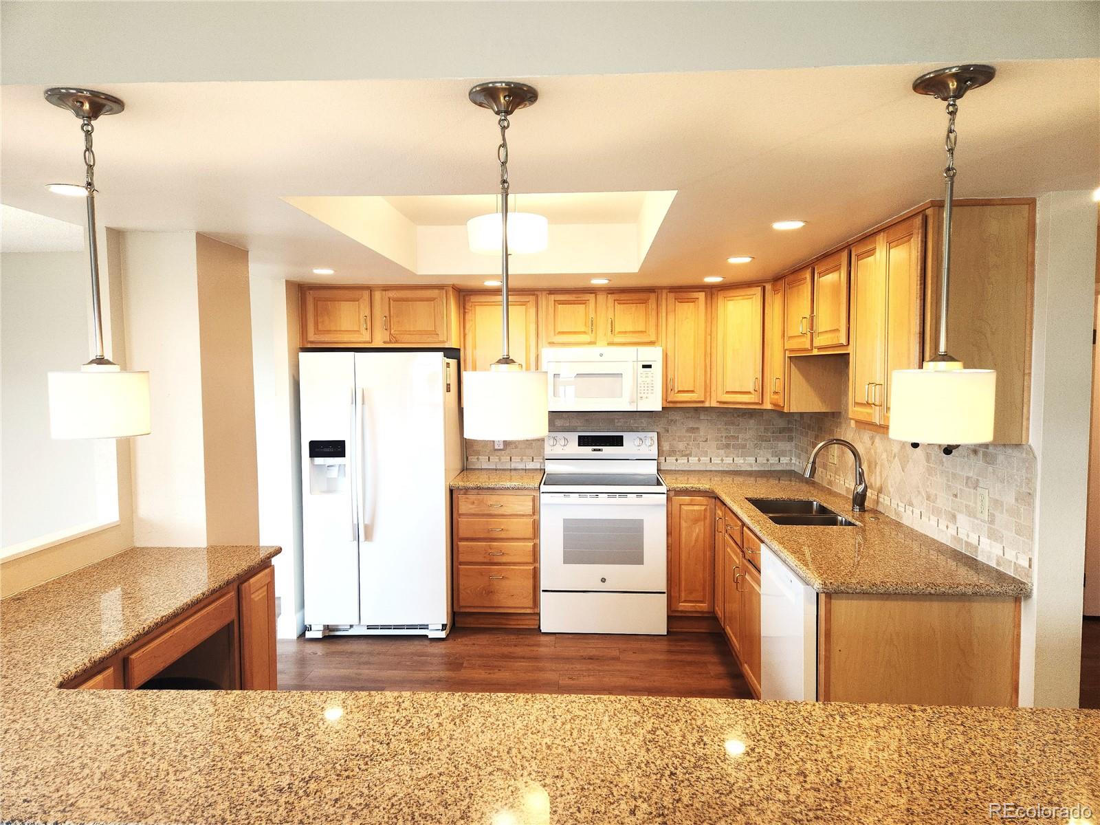 13890 East Marina Drive, Unit 602 Aurora, CO 80014 - Photo 11 of 27 a kitchen with stainless steel appliances granite countertop sink stove and refrigerator