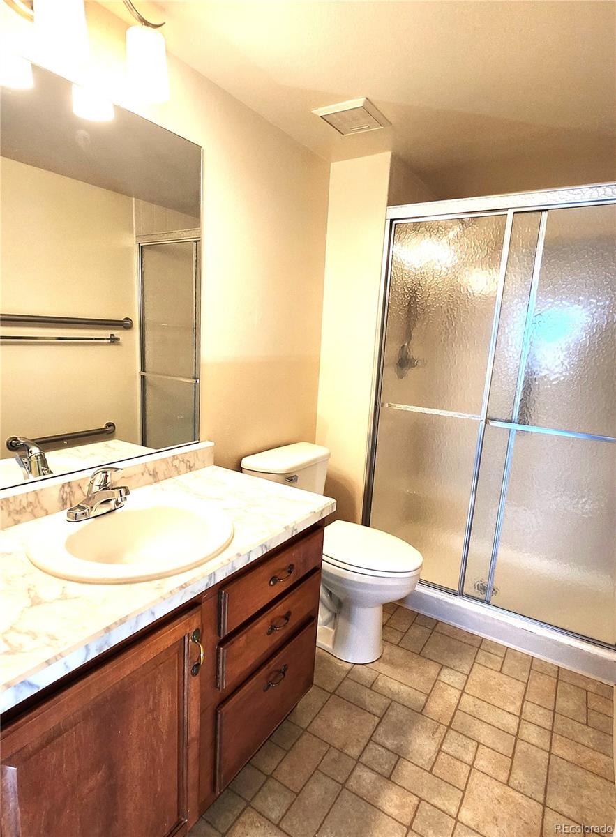 13890 East Marina Drive, Unit 602 Aurora, CO 80014 - Photo 19 of 27 a bathroom with a granite countertop sink toilet and shower
