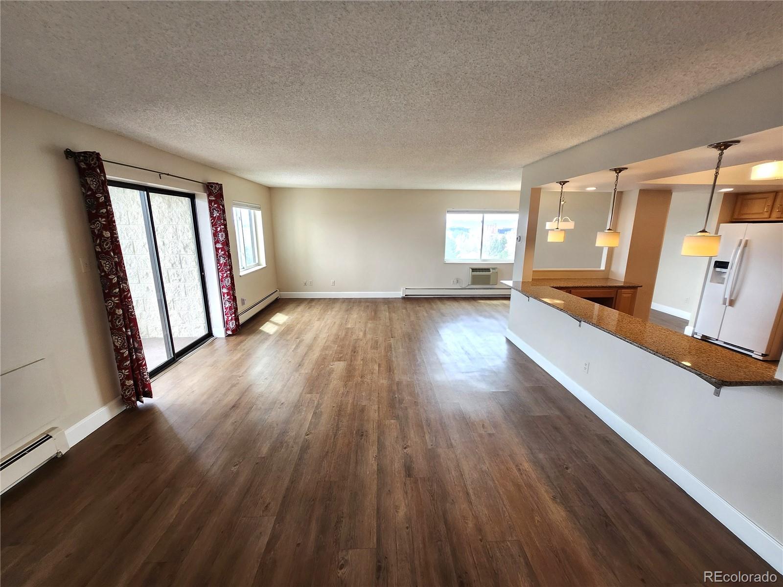 13890 East Marina Drive, Unit 602 Aurora, CO 80014 - Photo 2 of 27 an empty room with wooden floor and windows