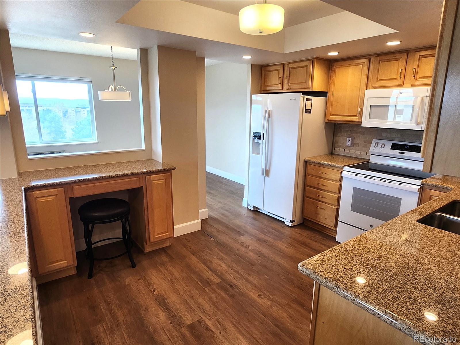 13890 East Marina Drive, Unit 602 Aurora, CO 80014 - Photo 10 of 27 a kitchen with stainless steel appliances granite countertop a refrigerator a stove and a wooden floors