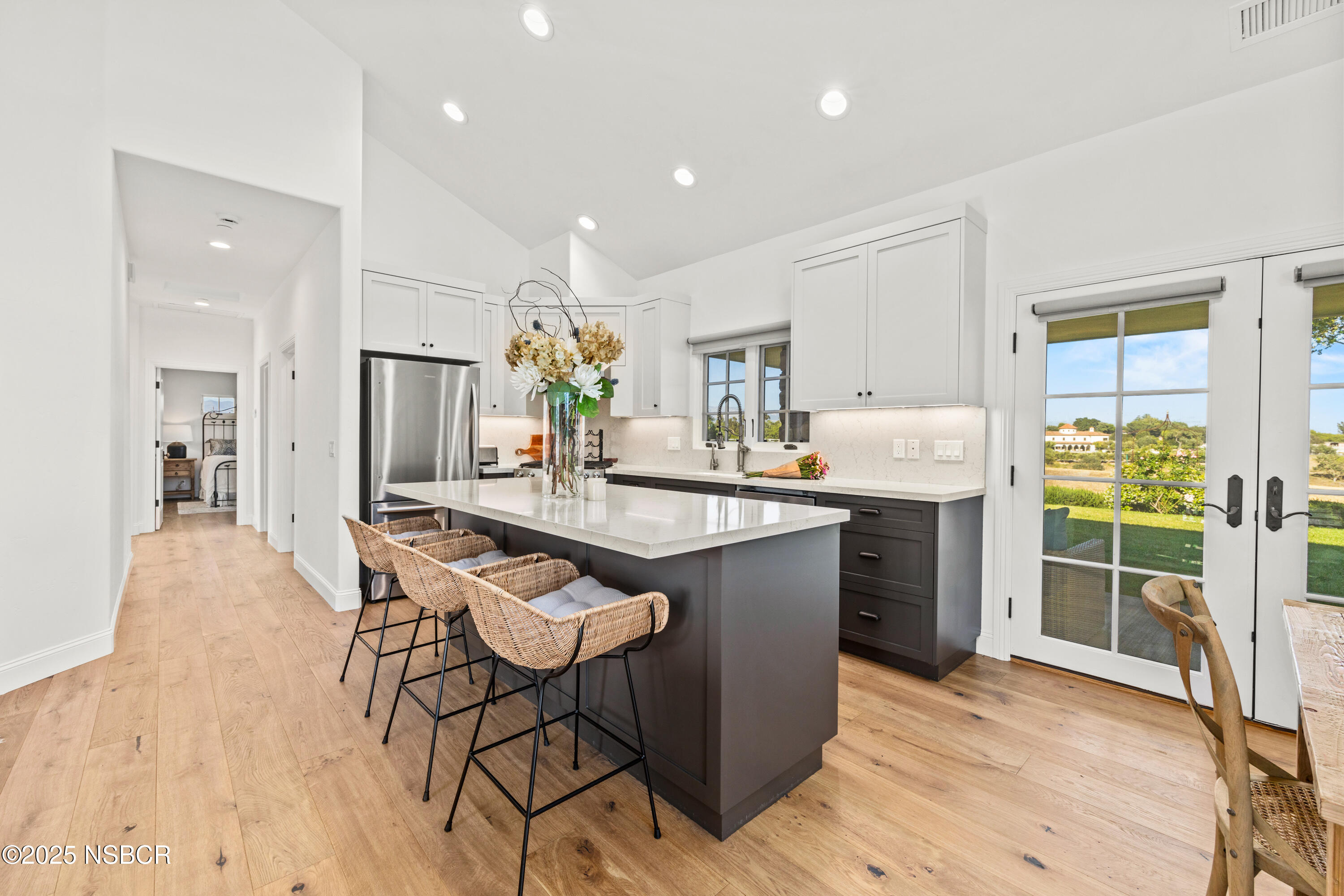 1740 Still Meadow Road Solvang, CA 93463 - Photo 13 of 43 a kitchen with stainless steel appliances kitchen island granite countertop a refrigerator a stove a sink dishwasher and white cabinets with wooden floor