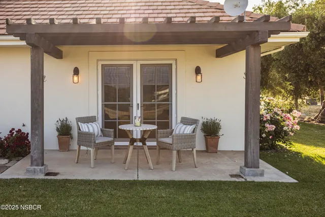 a view of a house with a big yard potted plants and large tree