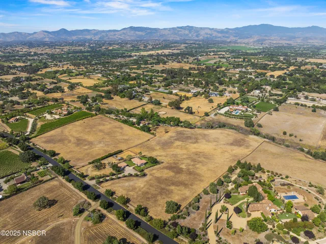 an aerial view of residential house and sandy dunes