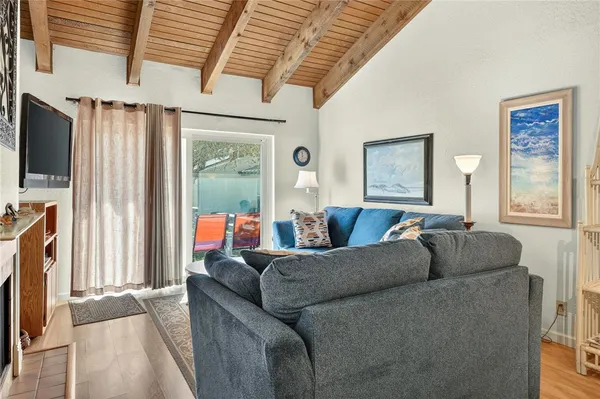 a living room with furniture a flat screen tv and a window