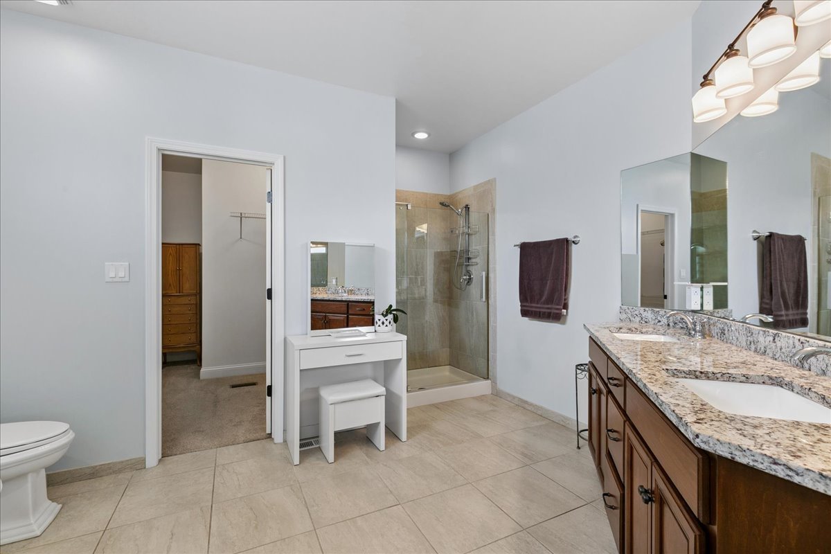 1015 Meadow Path Manteno, IL 60950 - Photo 13 of 26 a spacious bathroom with a granite countertop sink a toilet and a mirror