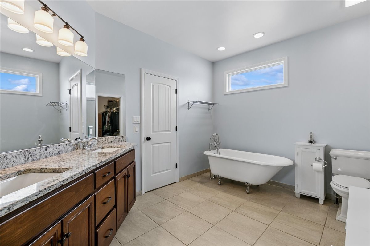 1015 Meadow Path Manteno, IL 60950 - Photo 14 of 26 a spacious bathroom with a granite countertop sink a toilet mirror and vanity
