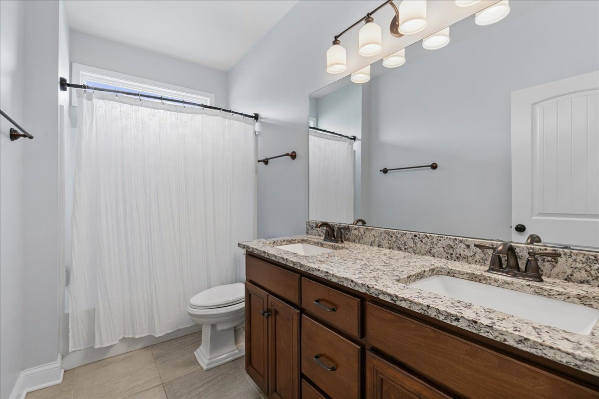 1015 Meadow Path Manteno, IL 60950 - Photo 16 of 26 a bathroom with a granite countertop sink a toilet and a mirror