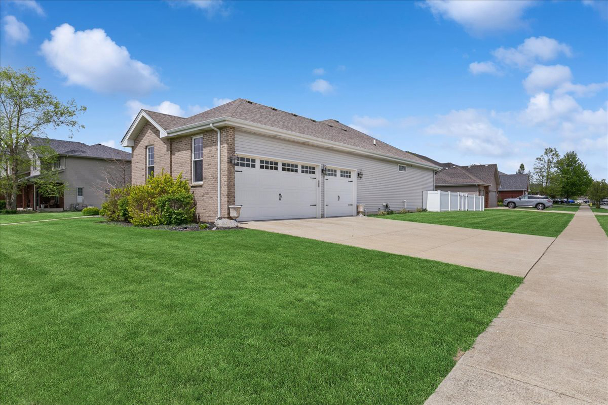 1015 Meadow Path Manteno, IL 60950 - Photo 2 of 26 a view of a white house in front of a big yard with plants and large trees