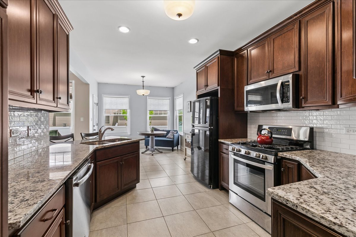 1015 Meadow Path Manteno, IL 60950 - Photo 7 of 26 a kitchen with stainless steel appliances granite countertop a stove a sink and a microwave